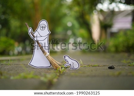 paper artwork of a girl and her cat sweep the yard with a broomstick