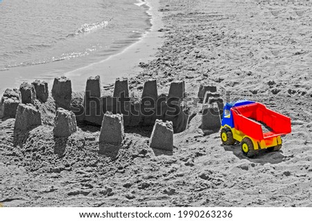 Childen's truck plastic toy with sand castle on the beach
