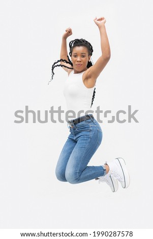 Afro american woman smiling in mid jump with her arms raised