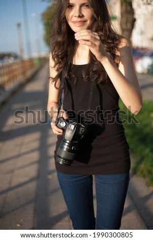 Outdoors portrait of young brunette tourist woman taking photos of the city.