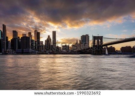 Manhattan city skyline in New York City from Brooklyn with the Brooklyn Bridge during Sunset on the East River in Summer of 2021