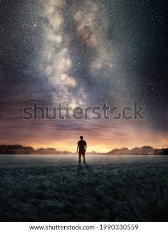 A man Exploring the night sky as the Milky Way galaxy fills the landscape from above. Photo composite