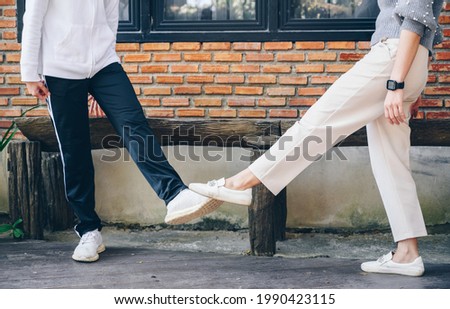 Two women doing foot tap for greeting during covid-19 pandemic. The foot tap or foot shake was suggested as an alternative way for reduce your risk of spreading or contracting the virus. Royalty-Free Stock Photo #1990423115