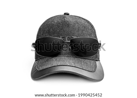 Black mens baseball cap with sunglasses on white background.