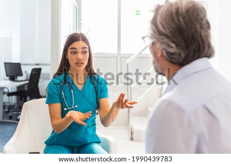 Doctor consulting patient in hospital waiting room. Patient sitting . Diagnostic, prevention of diseases, healthcare, medical service, consultation or education, healthy lifestyle concept