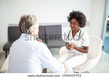 Doctor consulting patient in hospital waiting room. Patient sitting . Diagnostic, prevention of diseases, healthcare, medical service, consultation or education, healthy lifestyle concept