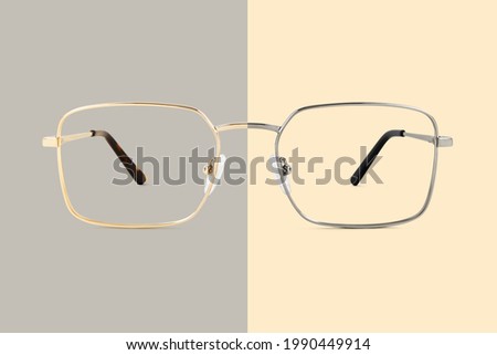 Silver and golden metal color eye glasses isolated on beige and gray background, ideal photo template for display or advertising sign or for a web banner
