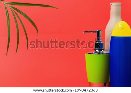 Palm leaf and a set of cosmetics for hair and body care on an orange background. Sale of cosmetics. Copy space