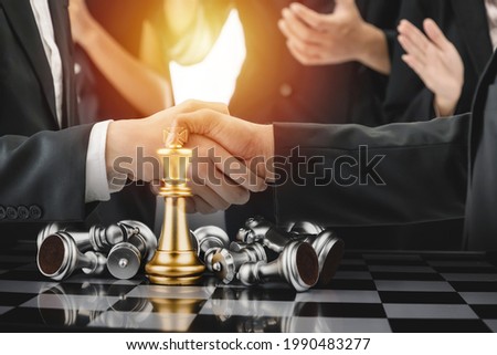 double exposure image of business team work shaking hand while their colleagues applauding in meeting room office with chess board game competition, planning, teamwork and business strategy concept