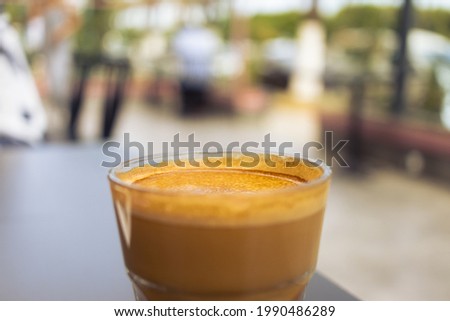 Delicious coffee in a coffee shop outside during the summer on a sunny day. The coffee type is cortado.