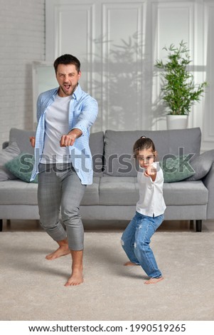 father and his cute little daughter train at home. Royalty-Free Stock Photo #1990519265