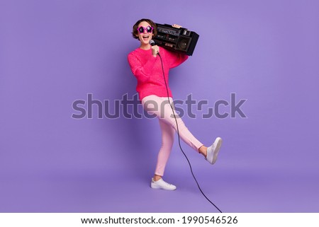 Full size photo of young excited girl happy have fun sing song microphone hold retro boombox isolated over purple color background