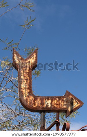 old rusty entrance sign with arrow
