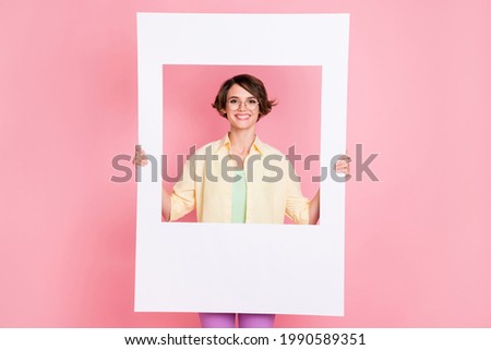 Photo of optimistic brunette lady hold frame wear shirt isolated on pastel pink color background