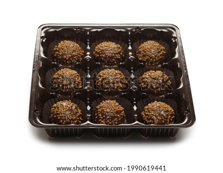 Chocolate truffles with caramel filling and peanut flavor in plastic packaging isolated on white background