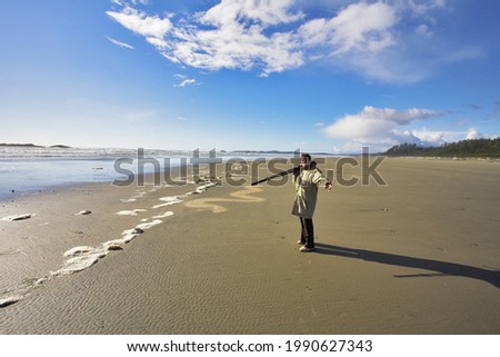 The woman-photographer with photographic equipment in hands on coast of ocean