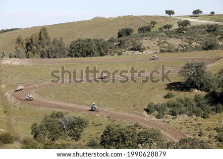 Motocross track photographed from afar with several runners