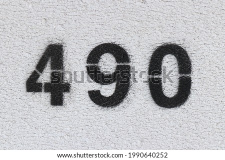 Black Number 490 on the white wall. Spray paint.