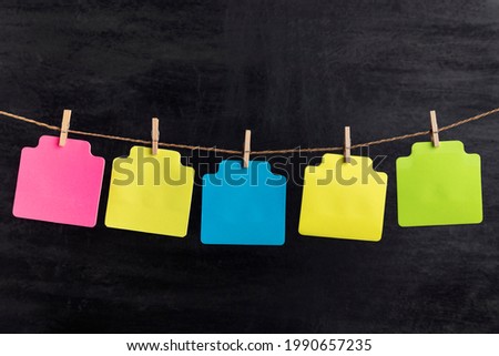Small blank multicolored paper cards hang with clothespin on rope. Copy space. Place for your text