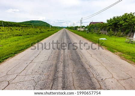 Country road with asphalt in cracks