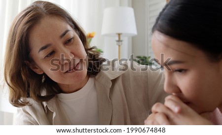 unhappy young adult asia people female lady feel sorry cry upset pensive share moment negative issue with old mum help consult sit sofa couch at home hand stroking hug cuddle love protect compassion. Royalty-Free Stock Photo #1990674848