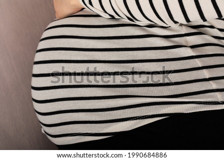 Picture of a pregnant woman with hands on her belly