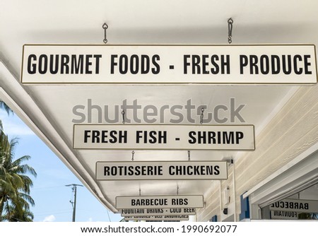 Perspective of prepared-food signs hanging outside a delicatessen on a barrier island along the Gulf Coast of Florida