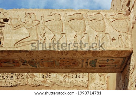 Stone lintel in the Ancient Egyptian temple of Medinet Habu carved with the images of the great Pharaoh Ramses II and a line of baboons.  West Bank of the River Nile in Luxor, Egypt.