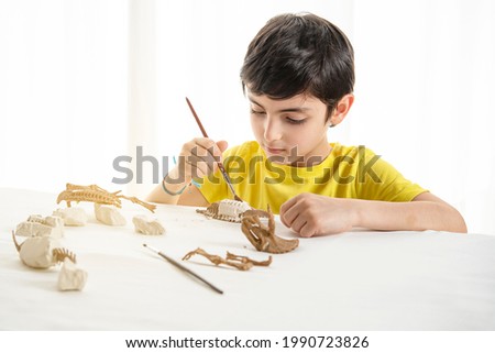 Young child plays as a paleontologist at home Royalty-Free Stock Photo #1990723826