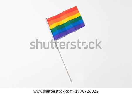 Rainbow flag of lgtbi community with hard shadow on white background. Pride day concept