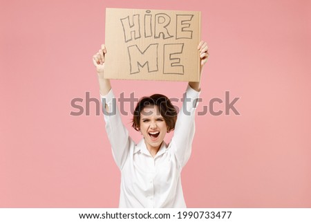 Young employee business secretary woman corporate lawyer wearing classic formal white shirt work in office hold cardboard sign card need job above head scream isolated on pastel pink background studio