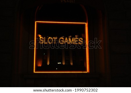 Neon inscription "Slot games" on black background