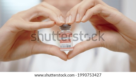 Vaccine COVID-19 coronavirus in the doctor hands medical with heart shape corona virus treatment and holding vaccine with a glass vial. Concept of love, attentive, caring, careworn, care.