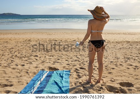 A girl standing on the beach and holding a mask
