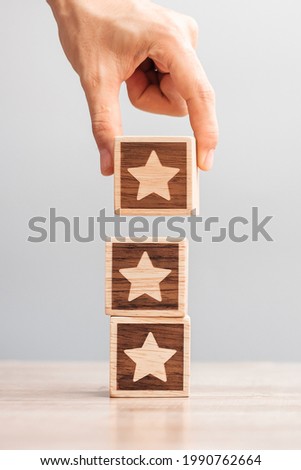 Man hand holding Star block. Customer choose rating for user reviews. Service rating, ranking, customer review, satisfaction, evaluation and feedback concept Royalty-Free Stock Photo #1990762664