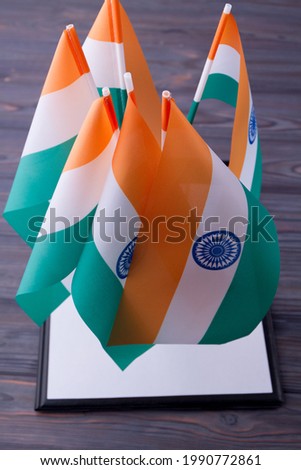 Vertical shot collection of indian flags on grey wood background.
