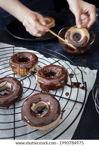 
Homemade and healthy dark chocolate donuts. Healthy homemade pastry. Cook soaked homemade donuts in melted chocolate Royalty-Free Stock Photo #1990784975