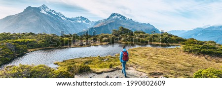 New Zealand Hiking. Young hiking man walking on trail at Routeburn Track during sunny day. Hiker tramping Key Summit Track in Fiordland National Park in New Zealand. Panoramic banner