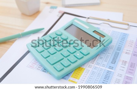 Eyeglasses, coffee and calculator on an office desk