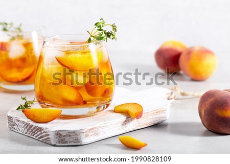 iced carbonated tea with peaches and mint in a glass on a gray background, horizontal Royalty-Free Stock Photo #1990828109