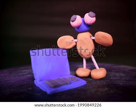 Cartoon clay man stand with laptop on blueish background