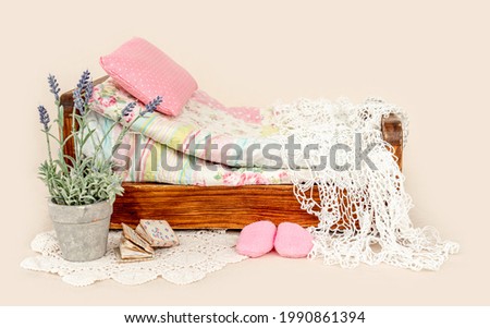 Beautiful bed furniture for newborn studio photoshoot with purple flowers decoration, pink pillow and blankets. Tiny designed place for infant photo isolated on background