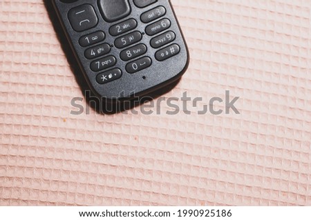 A top view of an old school button mobile on a patterned surface Royalty-Free Stock Photo #1990925186