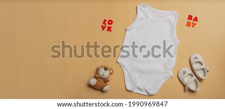 Baby clothes mockup template blank white jumpsuit for newborns, shoes and teddy bear on beige background. Space for text, top view. Banner