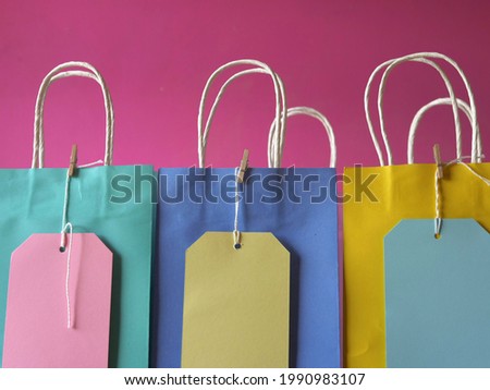 Gift bags and labels on pink background medium shot