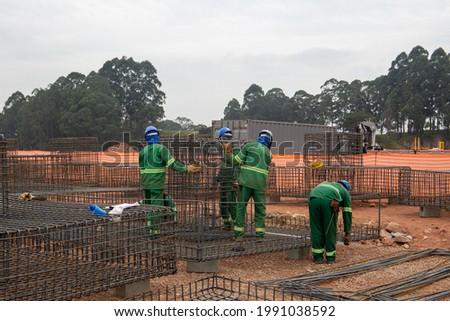 men working with iron in a large building