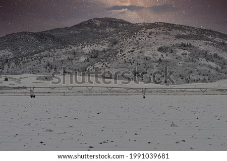 A mesmerizing view of snow-covered mountains under a scenic starry sky