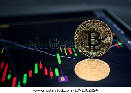 Bitcoin currency with blockchain concept on laptop and charts and graphs.