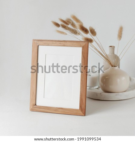 Frame mockup, modern ceramic vasen with dry branches and marble tray on light backdrop. Copy space.Scandinavian interior.