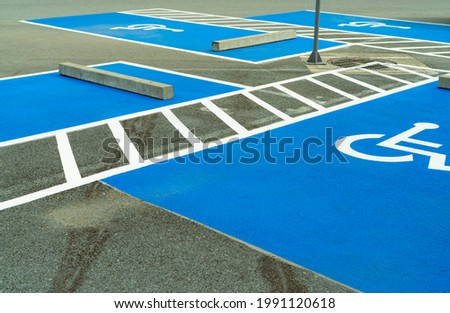 Asphalt car parking lot reserved for handicapped driver in supermarket or shopping mall. Car parking space for disabled people. Wheelchair sign paint on asphalt parking area. Handicapped parking lot.
